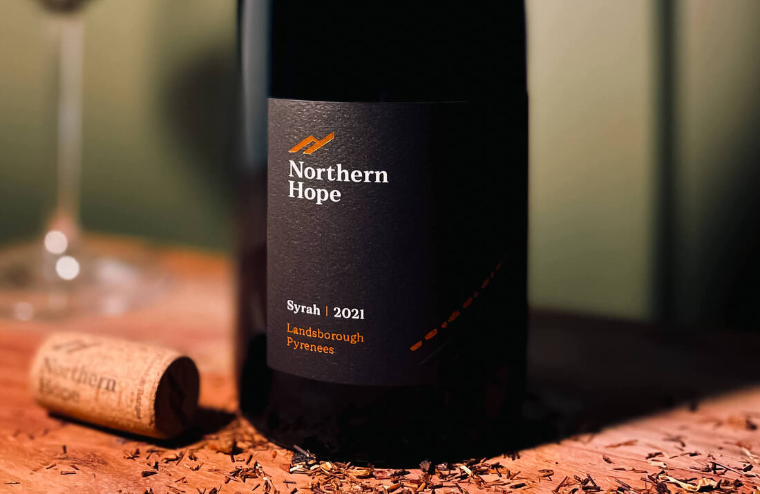 Northern Hope Syrah 2021 bottle of wine set on an oak table